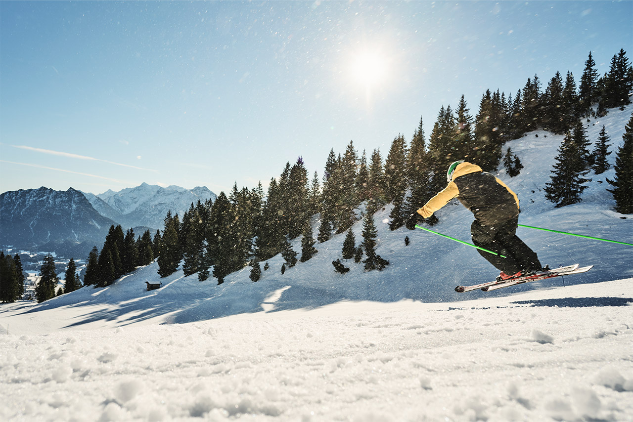 Skifahrer, welcher den Berg hinunter fährt.