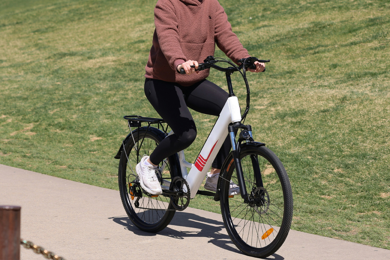 Eine Frau fährt auf einem E-bike einen Weg entlang.