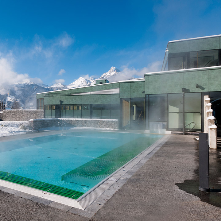 Der Außenbereich der Alpentherme Ehrenberg Reutte. Ein dampfender Swimmingpool. 