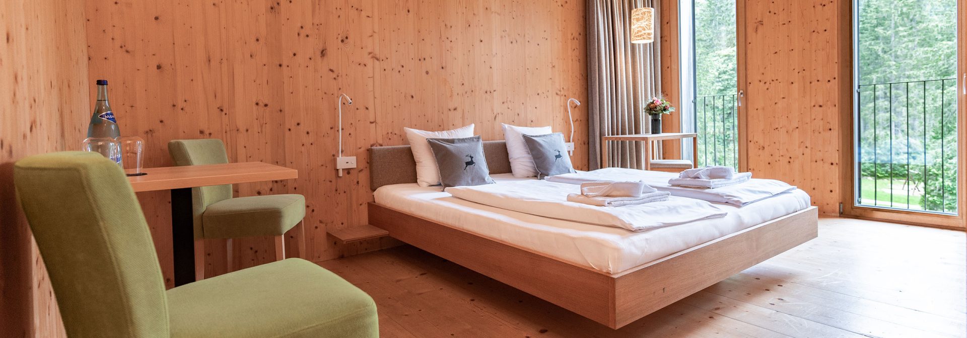 Innenansicht eines Holzverkleideten Zimmers des Alpenhotel Ammerwald.