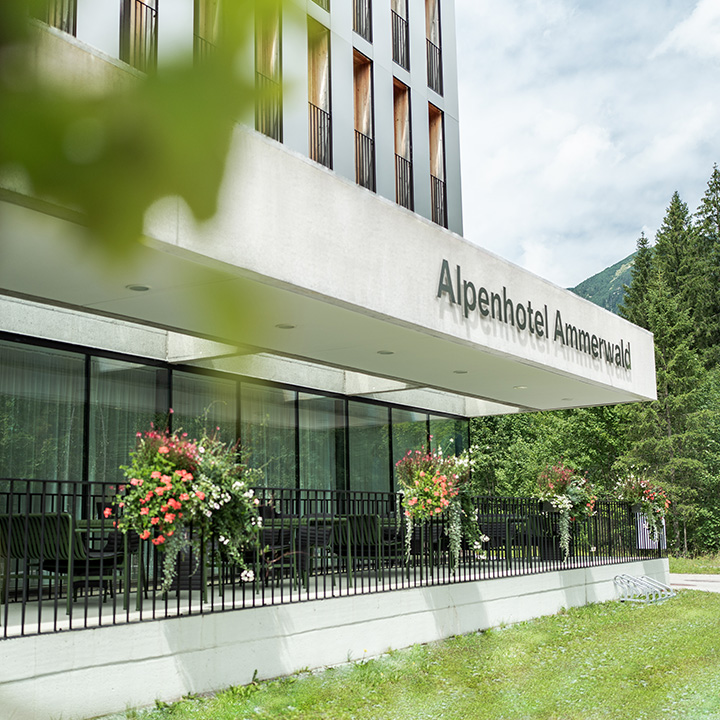 Außenansicht des Alpenhotel Ammerwald, dekoriert mit Blumen. 