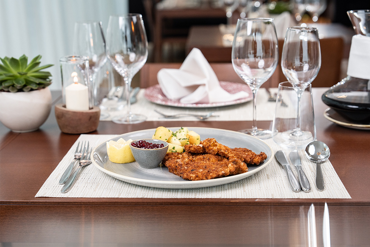 A laid table with Viennese Schnitzel on it.