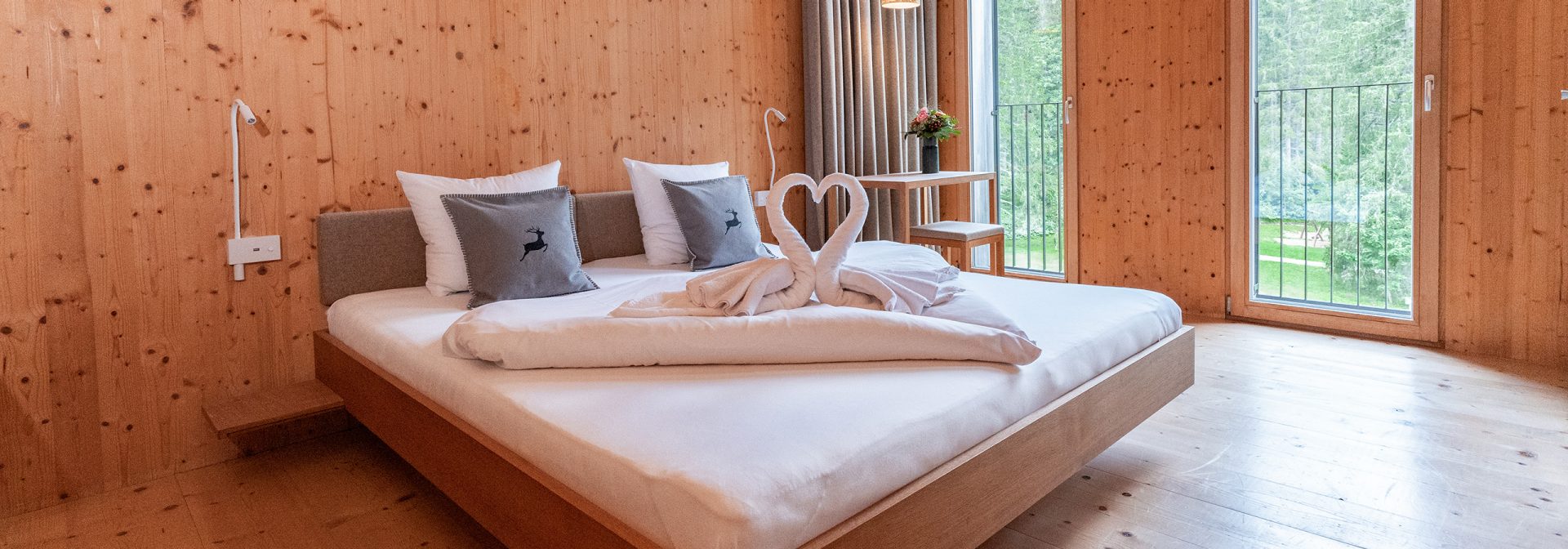  Aufnahme von zwei aus Handtüchern geformten Schwänen auf dem Bett.