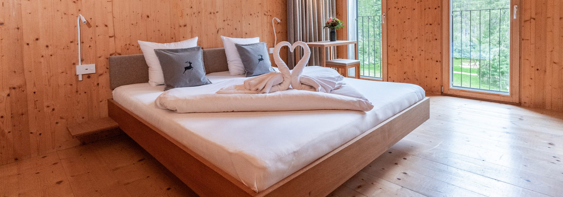 Holzverkleidetes Hotelzimmer mit Stühlen und einem Bett