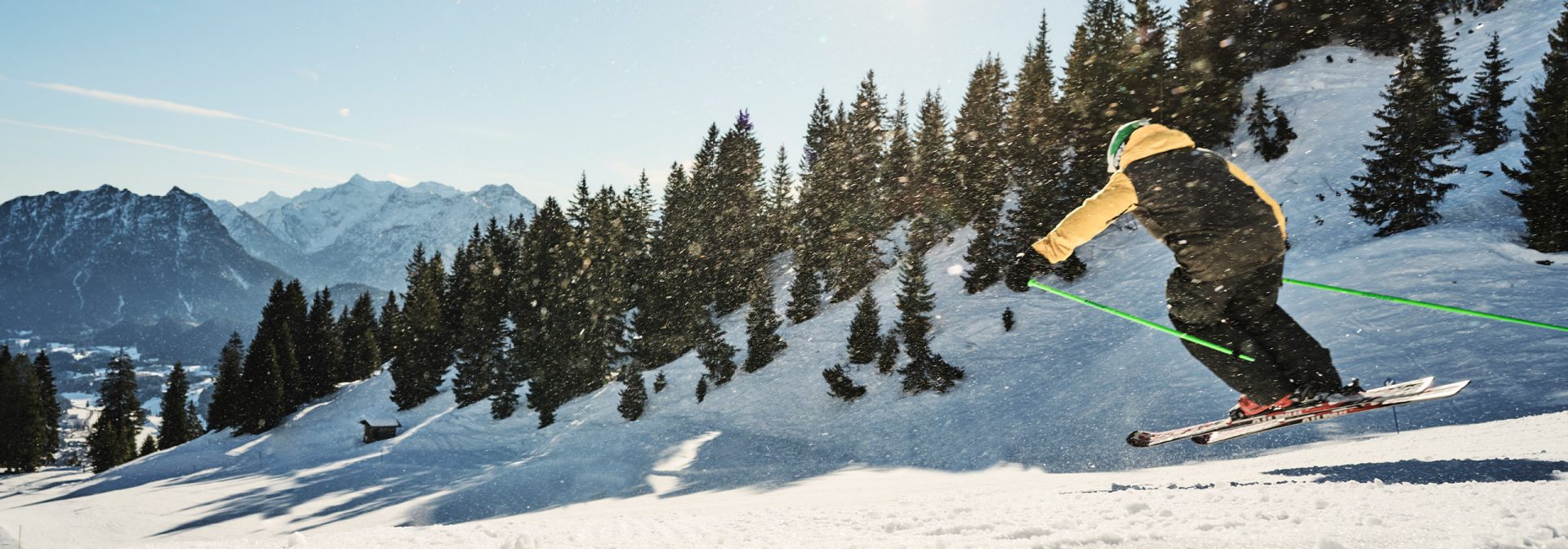A skier performing a jump on a snowy mountain slope.