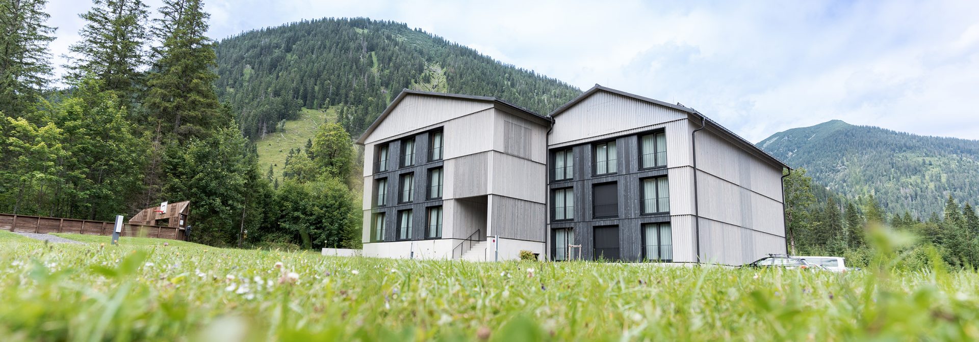 Exterior view of Alpenhotel Ammerwald surrounded by mountains.