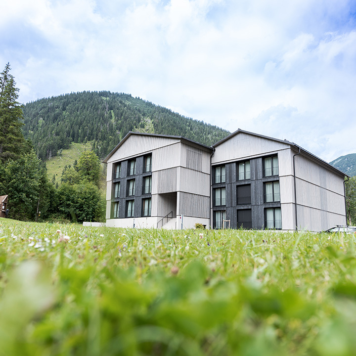 Exterior view of Alpenhotel Ammerwald surrounded by mountains.