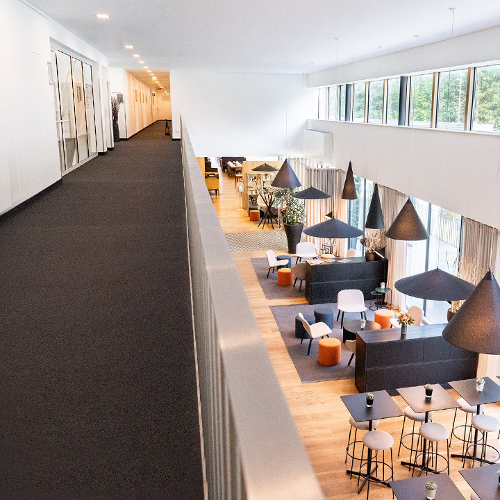 A modern interior view of a lounge with stylish furniture and pendant lights.