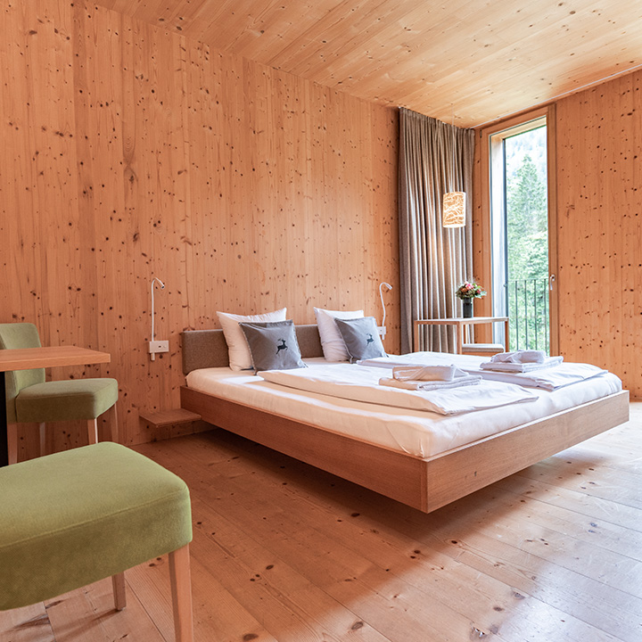 A stylish modern bedroom with wooden walls and a double bed.