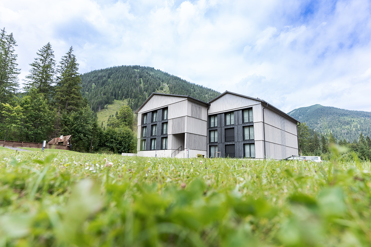 Exterior view of Alpenhotel Ammerwald surrounded by greenery.