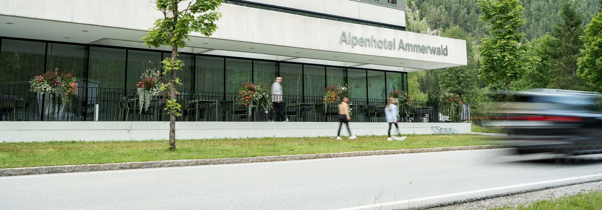 Exterior view of Alpenhotel Ammerwald with guests walking