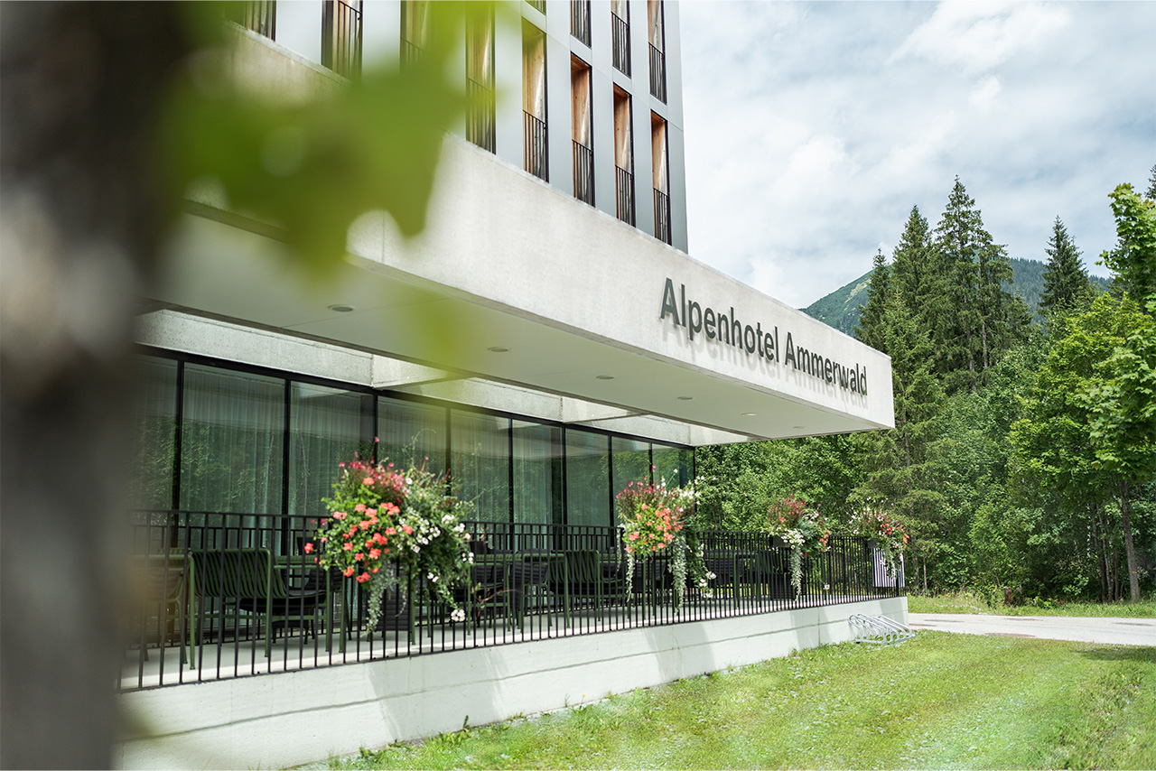View of the Alpenhotel Ammerwald exterior with floral decorations