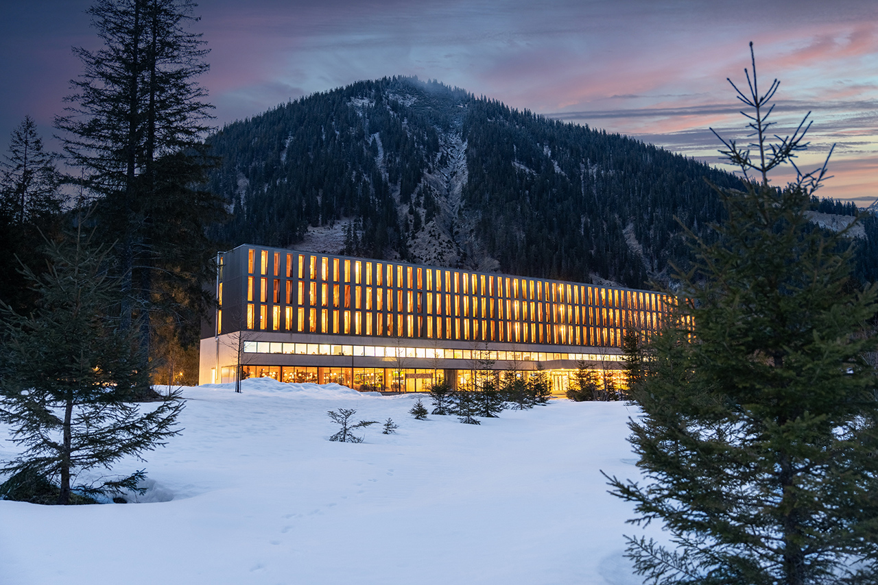 Exterior view of the Alpenhotel Ammerwald at night in winter.