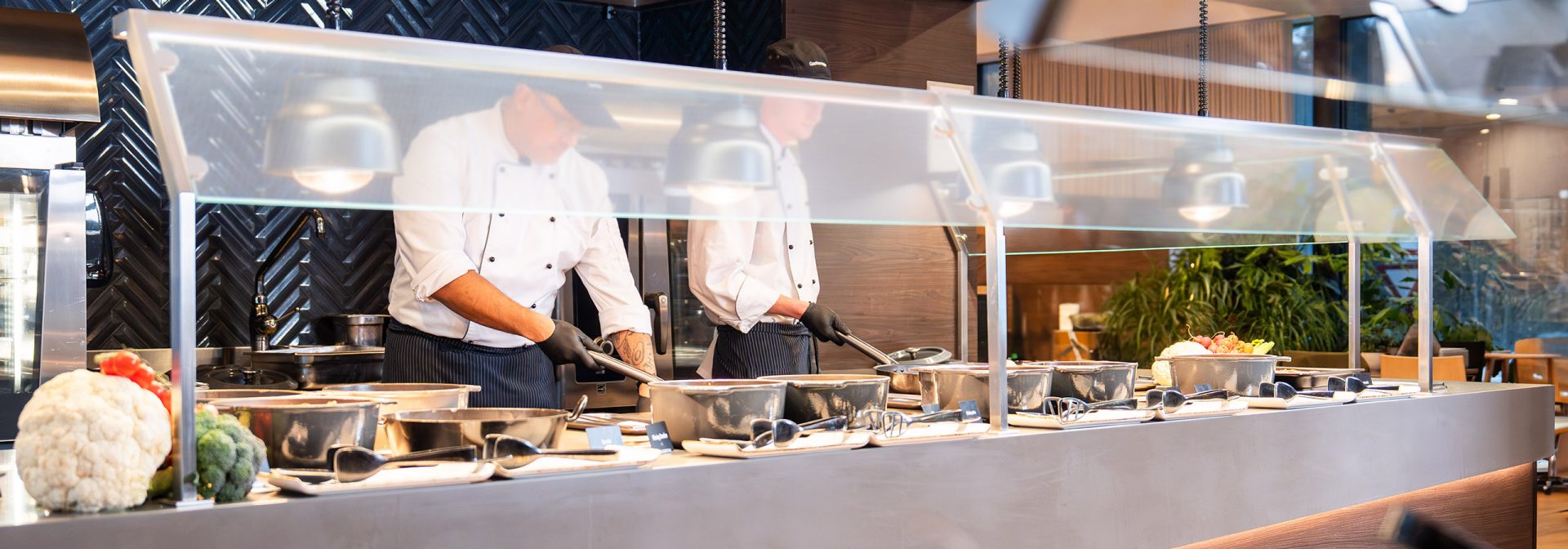 chefs cooking at a buffet station with fresh ingredients