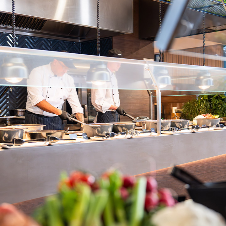 chefs cooking at a buffet station with fresh ingredients
