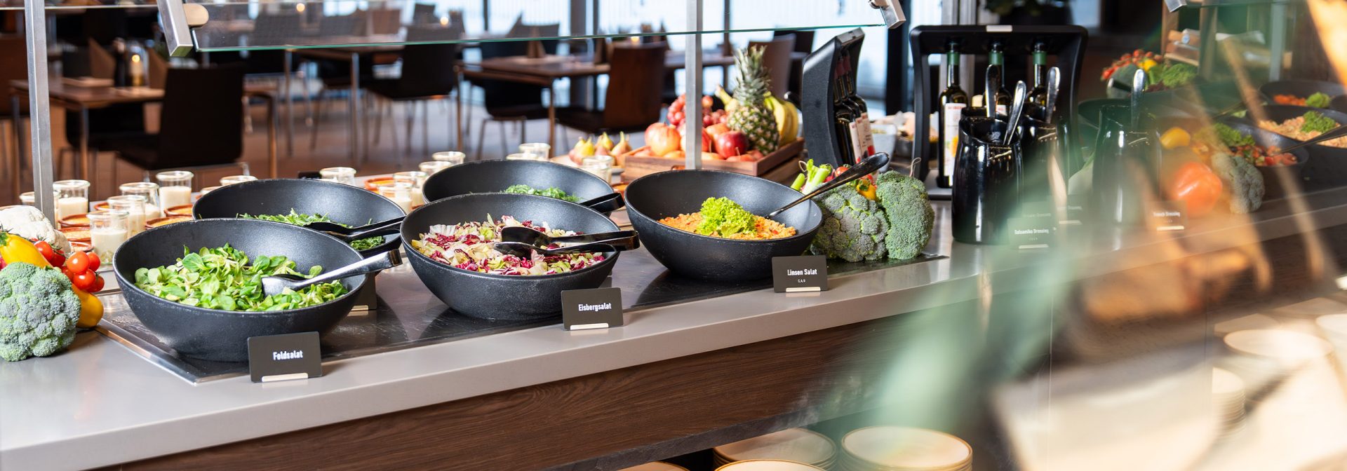 A vibrant salad bar with a variety of fresh vegetables and dressings.