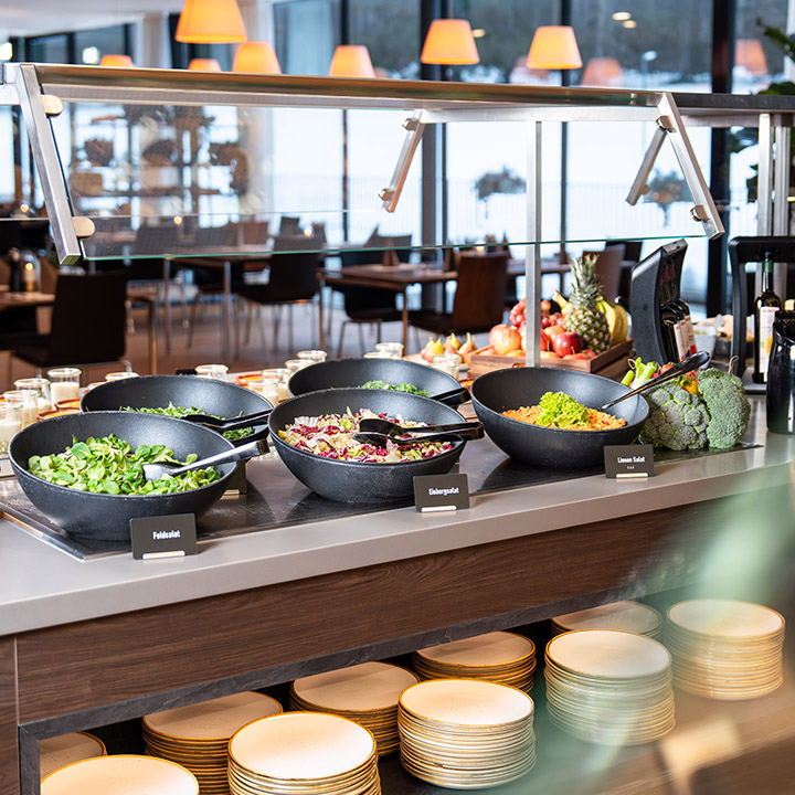A vibrant salad bar with a variety of fresh vegetables and dressings.