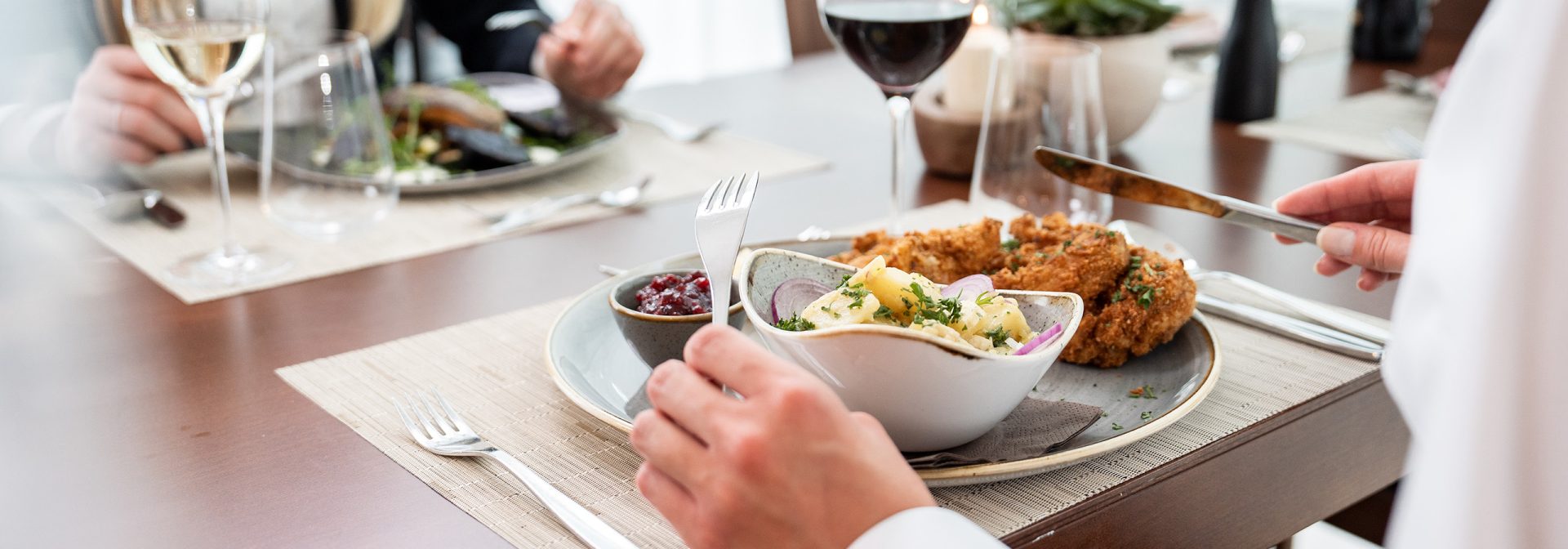 A gourmet dining experience featuring fried chicken and creamy pasta on a beautifully set table.