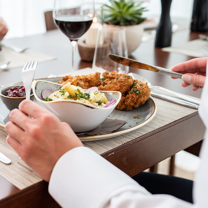 A gourmet dining experience featuring fried chicken and creamy pasta on a beautifully set table.