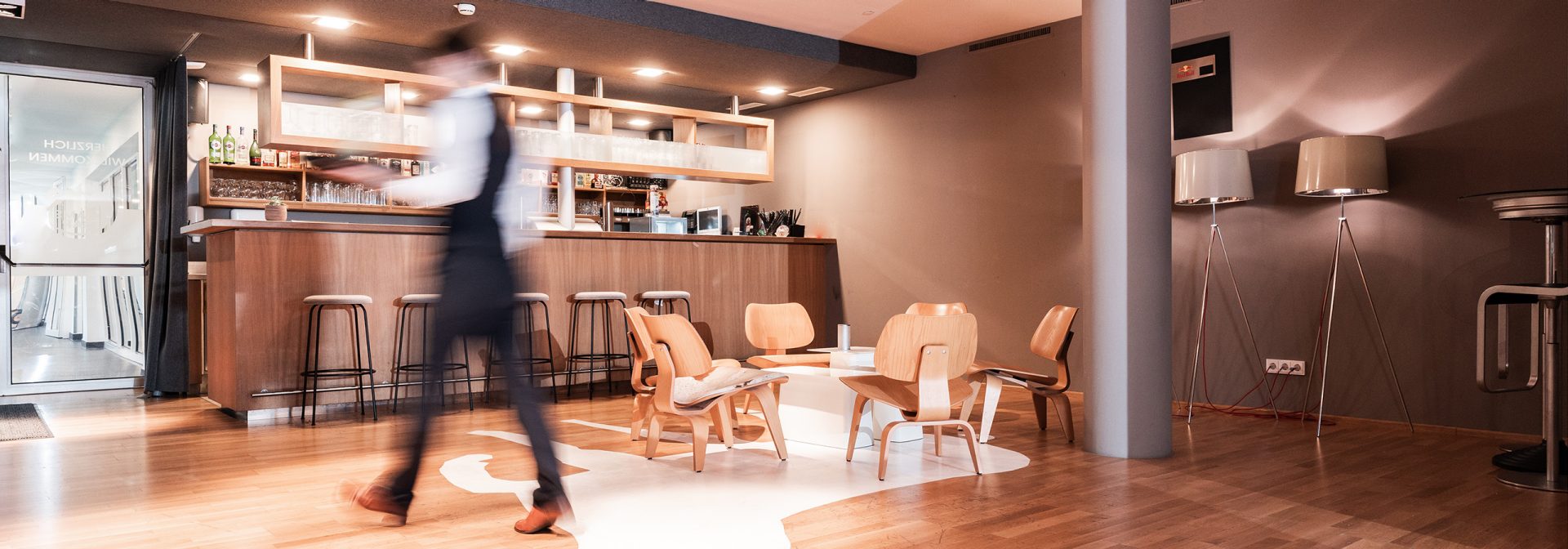  modern coffee shop interior featuring wooden furniture and a bar.