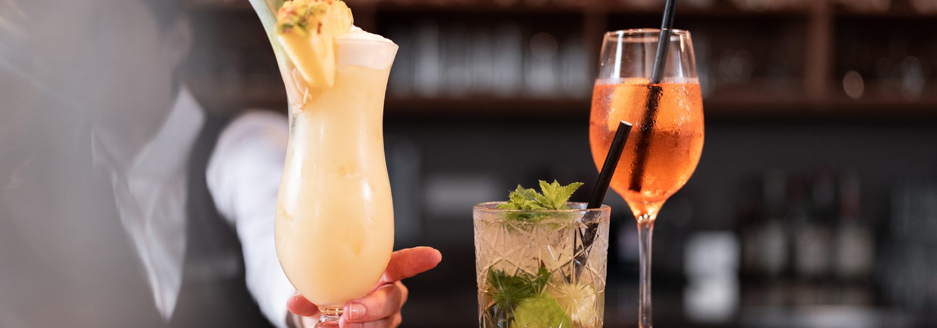 Three colorful tropical cocktails served in elegant glasses