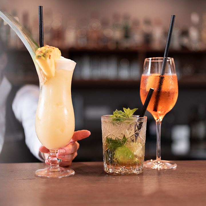 Three colorful tropical cocktails served in elegant glasses