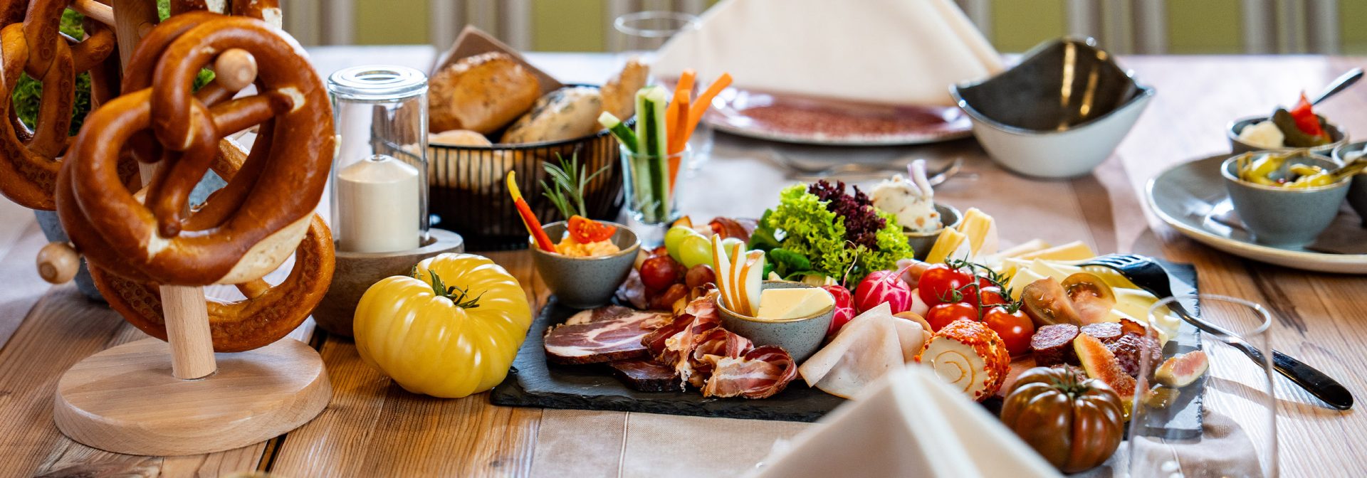 Gedeckter Tisch mir Gemüse, Obst und verschiedenen Käsesorten