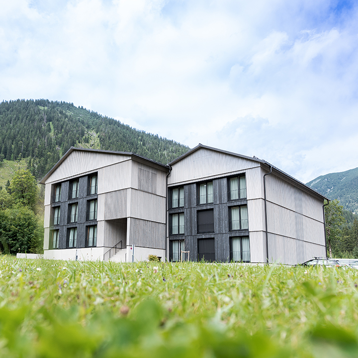 Exterior view of Alpenhotel Ammerwald surrounded by mountains.