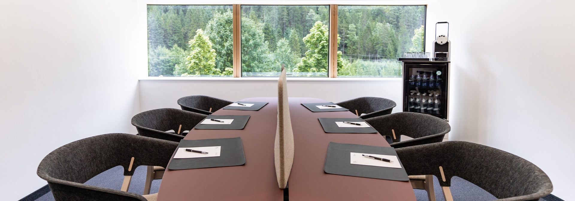 A workshop room with an oval table and seating for seven people.