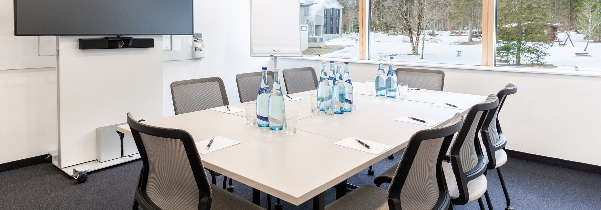 Workshop room with block-shaped table and seating for 8 people.