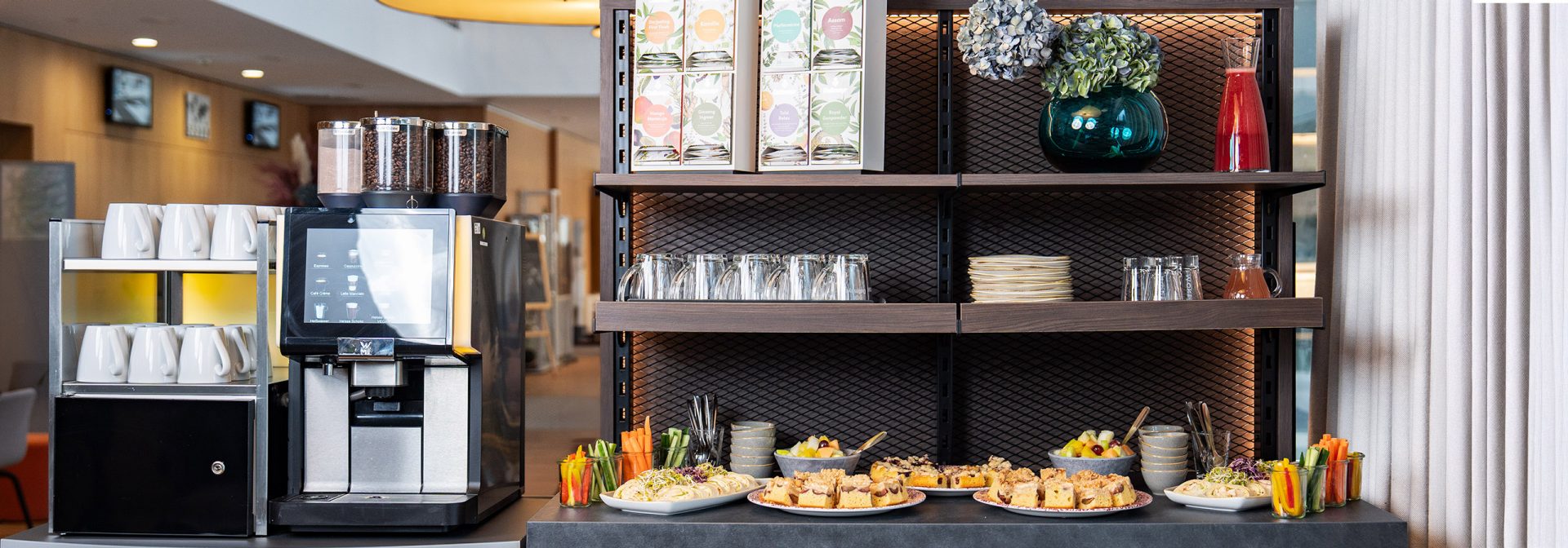 Tische, aneinandergereiht, mit Papier, Stift, Wasserflasche und Glas darauf.